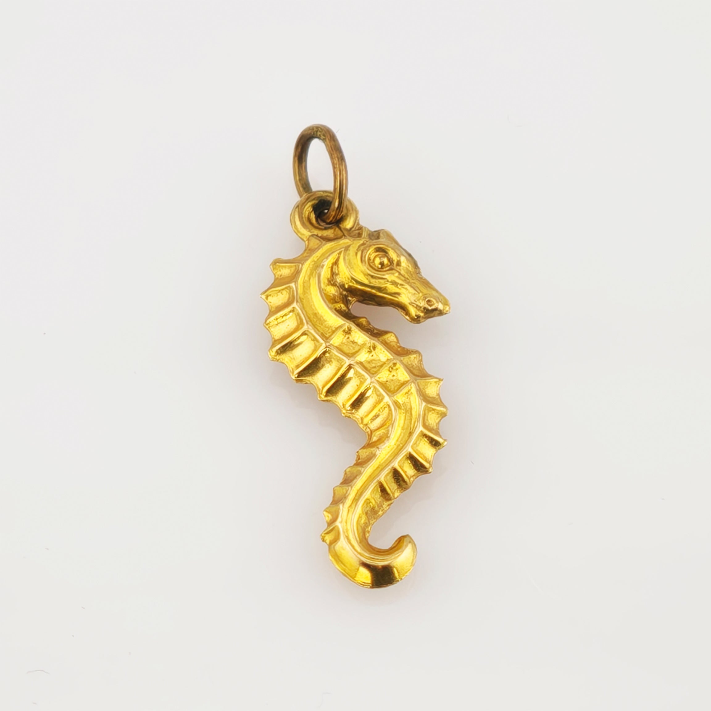 Goldener Seepferdchen-Anhänger mit detaillierten Verzierungen, ideal für Vintage-Schmuck.