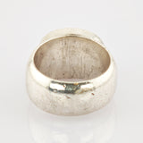 Antiker Metallring mit abgenutzter Oberfläche auf reflektierendem Weiß