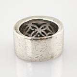 Breiter silberner Ring mit strukturierter Oberfläche und floralen Ausschnitten