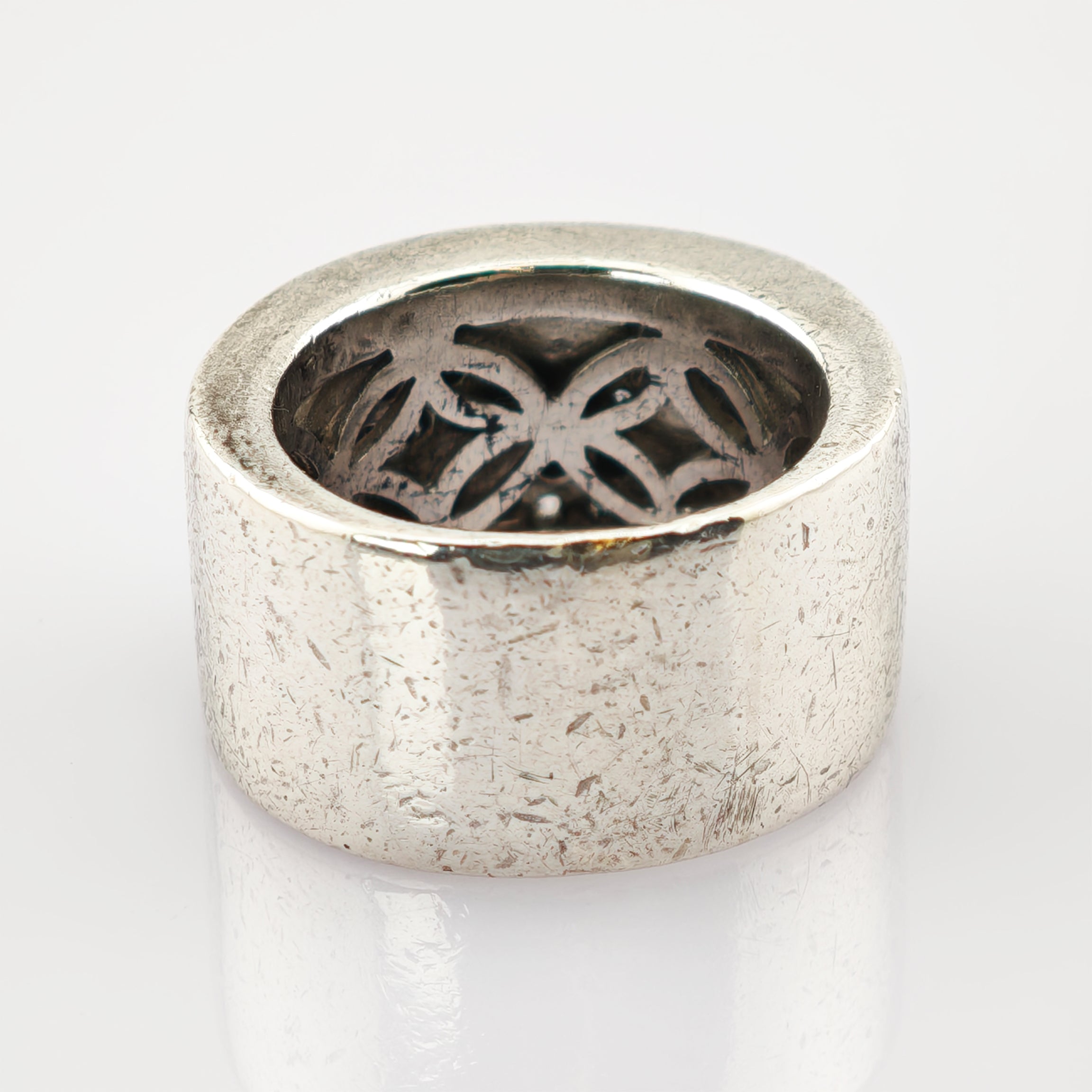 Breiter silberner Ring mit strukturierter Oberfläche und floralen Ausschnitten