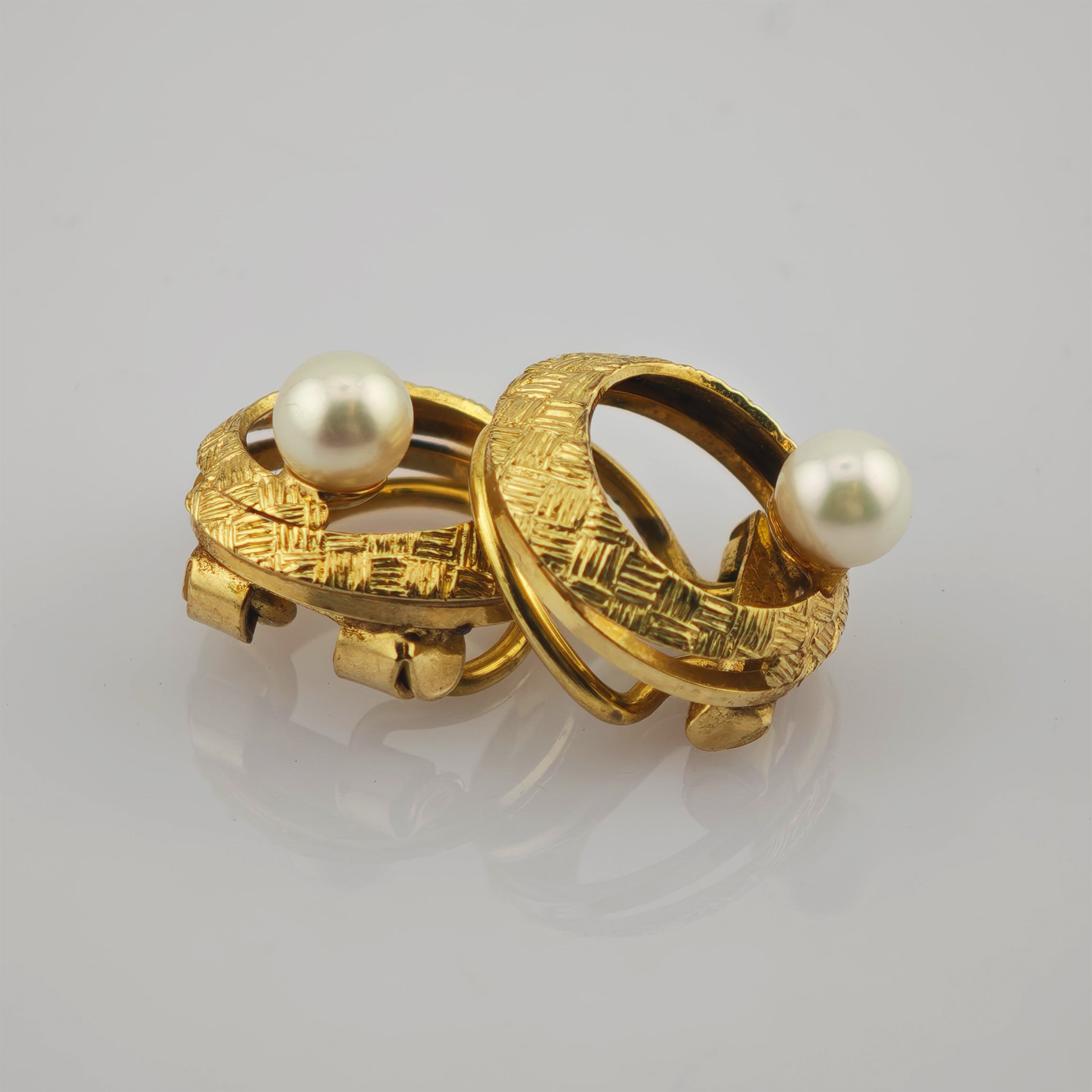 Zwei Creolen in Gold mit Perle und Fasermuster