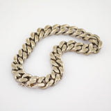 Dickes goldfarbenes Armband mit breiten, strukturierten Gliedern und sichtbarem Verschluss auf weißem Hintergrund.