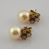 Elegante Ohrstecker mit großen runden cremigen Perlen und drei kleinen funkelnden Diamanten in Goldfassung.