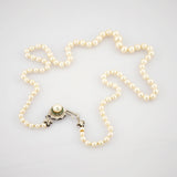 Elegante Perlenkette in Sternform mit cremefarbenen Perlen und verziertem Metallschloss.