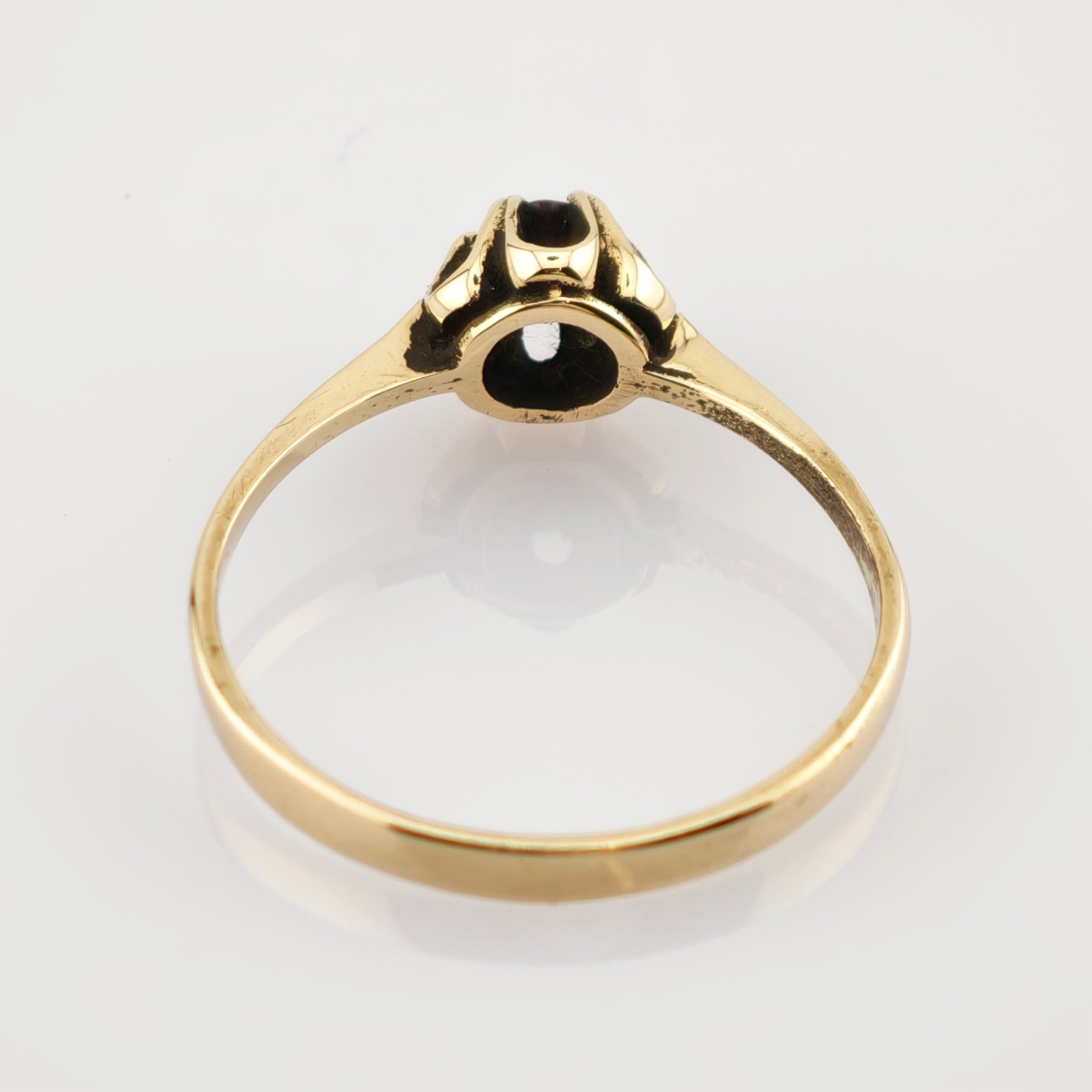 Eleganter Goldring mit dunklem Stein in Krallenfassung und polierter Oberfläche