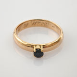 Eleganter Goldring mit glattem Band und kleinem rundem schwarzen Stein in Vierkrappefassung, Gravur W3099 innen.