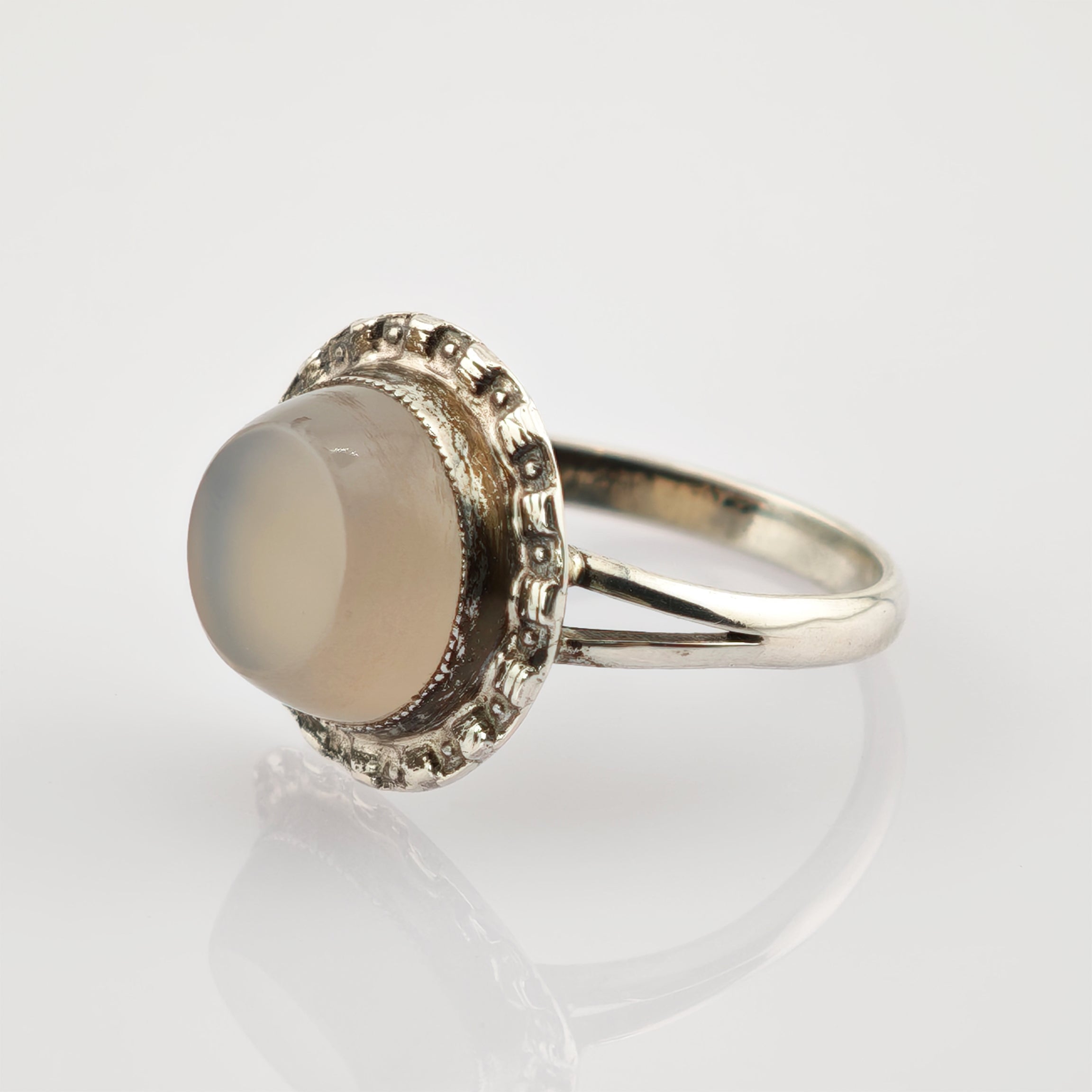 Eleganter silberner Ring mit beigem Stein und dekorativem Rahmen im Vintage-Stil.