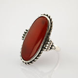Eleganter Silberring mit ovalem roten Stein und filigranen Details im Vintage-Stil.