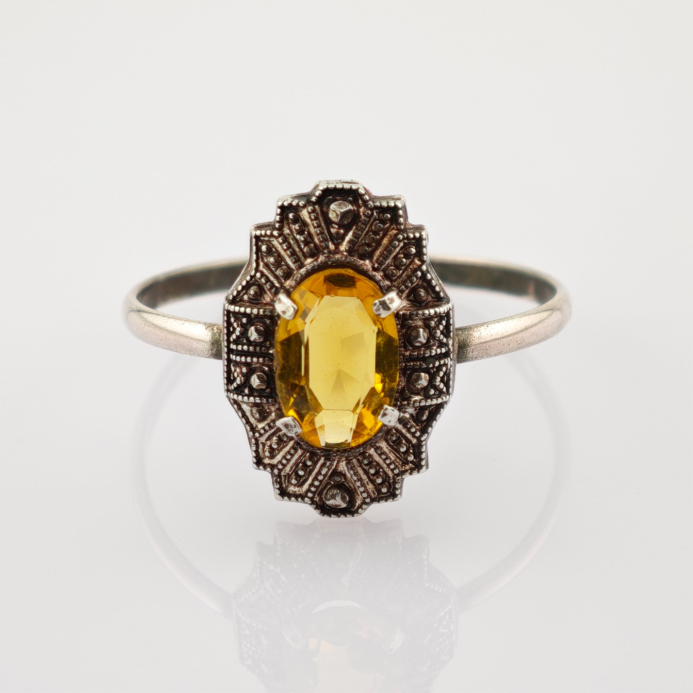Eleganter Vintage-Silberring mit detaillierter Verzierung und ovalem gelben Edelstein.