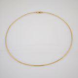 Feine goldene Halskette mit rundem Verschluss auf weißem Hintergrund