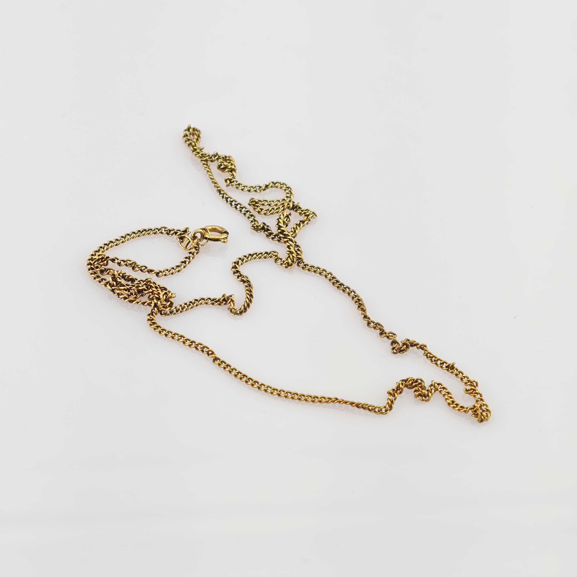 Feine Goldkette mit zierlichem Federringverschluss auf weißem Hintergrund