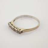 Feiner Goldring mit schmalem Band und fünf kleinen runden Steinen, 14K markiert.