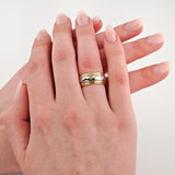 Zwei gepflegte Hände, eine trägt einen gold-silbernen Ring mit gelbem Edelstein und klaren Steinen.