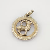 Runder Goldanhänger mit strukturiertem Außenring und Ziegenmotiv mit gebogenem Horn nach rechts.