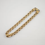 Goldene Gliederkette mit rechteckigen Verbindungselementen und Sicherheitsverschluss auf weißem Hintergrund