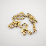 Goldene Halskette mit dicken, flachen, miteinander verbundenen Gliedern auf weißem Hintergrund