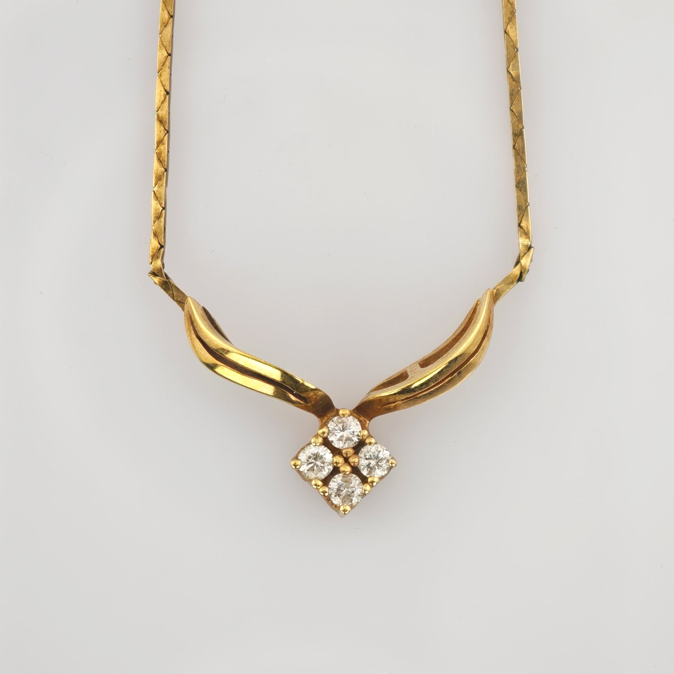 Goldene Halskette mit eleganter Anhängerkombination aus zwei gebogenen Teilen und vier klaren Edelsteinen.