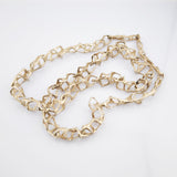 Goldene Halskette mit unregelmäßig geformten geometrischen Gliedern auf weißem Hintergrund