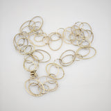 Goldene Halskette mit gehämmerten ovalen Gliedern auf weißem Hintergrund.