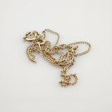 Goldene Halskette mit Toggle-Verschluss auf weißem Hintergrund