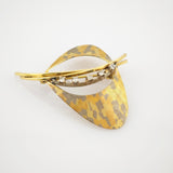 Goldene Vintage-Brosche in Teardrop-Form mit gelb-grauem Muster und sechs weißen Edelsteinen