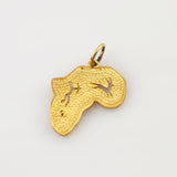 Goldener Anhänger in Form des afrikanischen Kontinents mit texturierter Oberfläche und zwei ausgeschnittenen Tiersilhouetten.