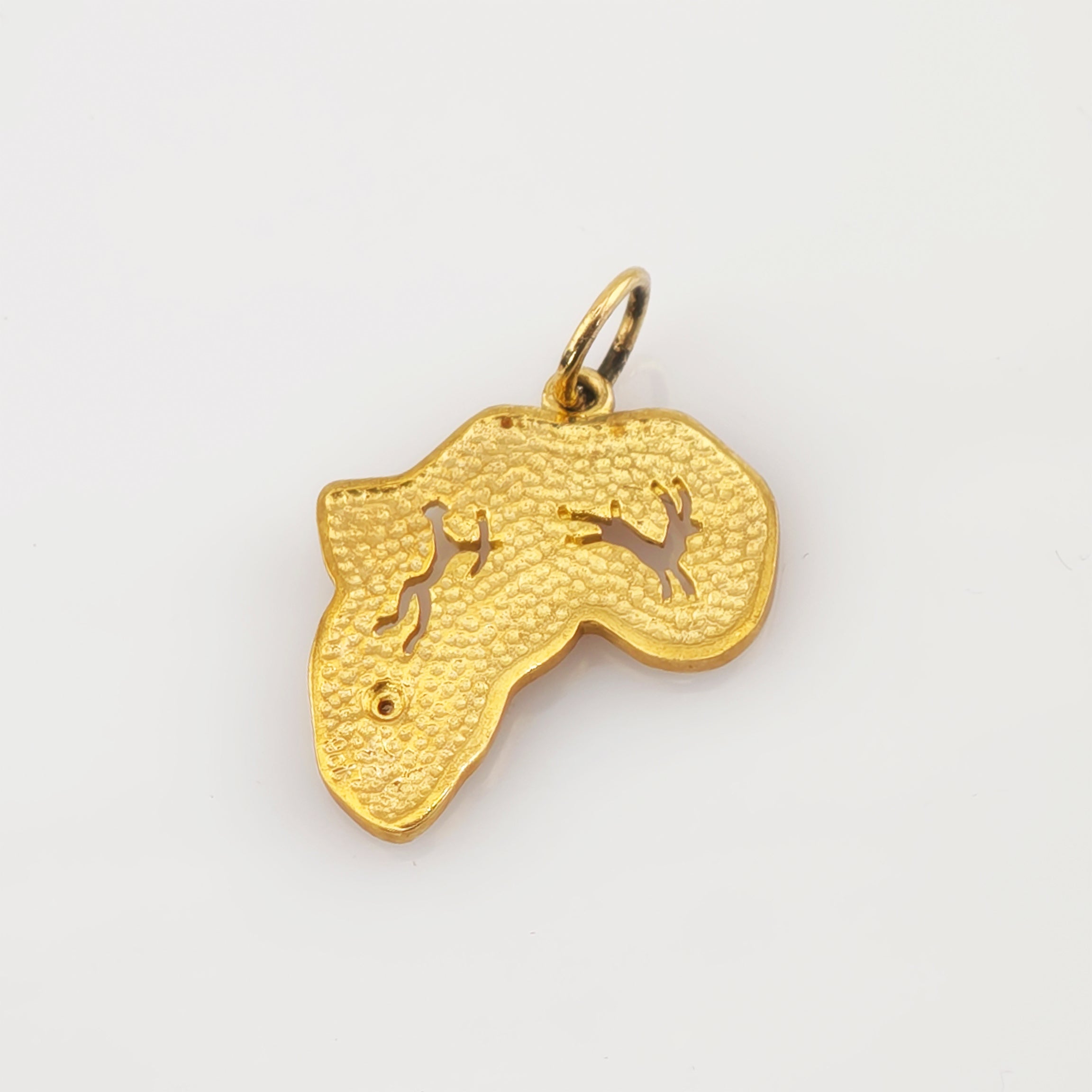 Goldener Anhänger in Form des afrikanischen Kontinents mit texturierter Oberfläche und zwei ausgeschnittenen Tiersilhouetten.
