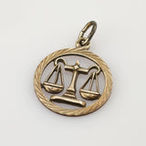 Goldener Anhänger mit Waage der Gerechtigkeit in einem runden Rahmen, Schmuckstück