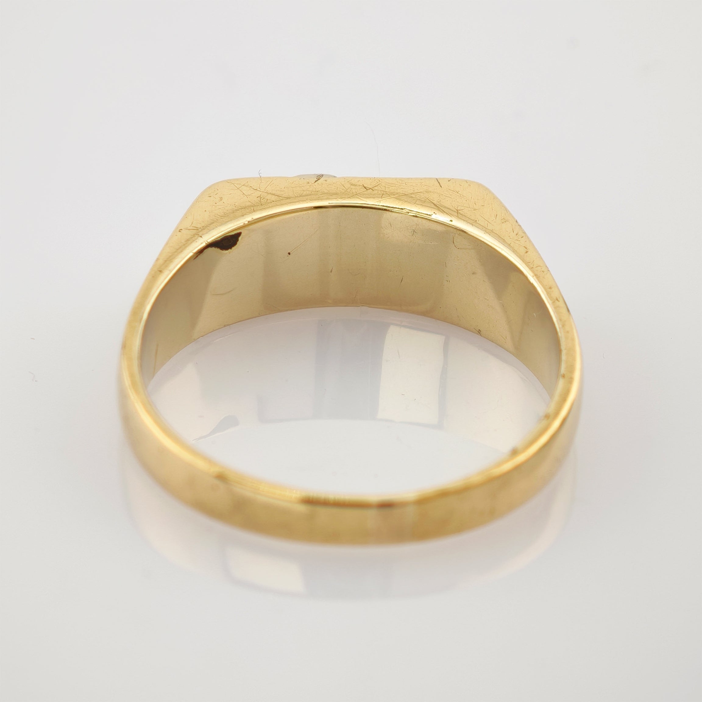 Goldener Petschaftsring mit breiter Oberfläche, kleinen Kratzern und dunklem Fleck am Rand