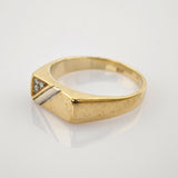 Goldener Ring mit quadratischem flachen Gesicht und drei Diamanten im Dreieck auf silbernem Band.