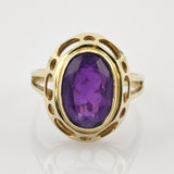 Goldener Ring mit ovalem Amethyst und offenem Design mit ovalen und runden Ausschnitten.