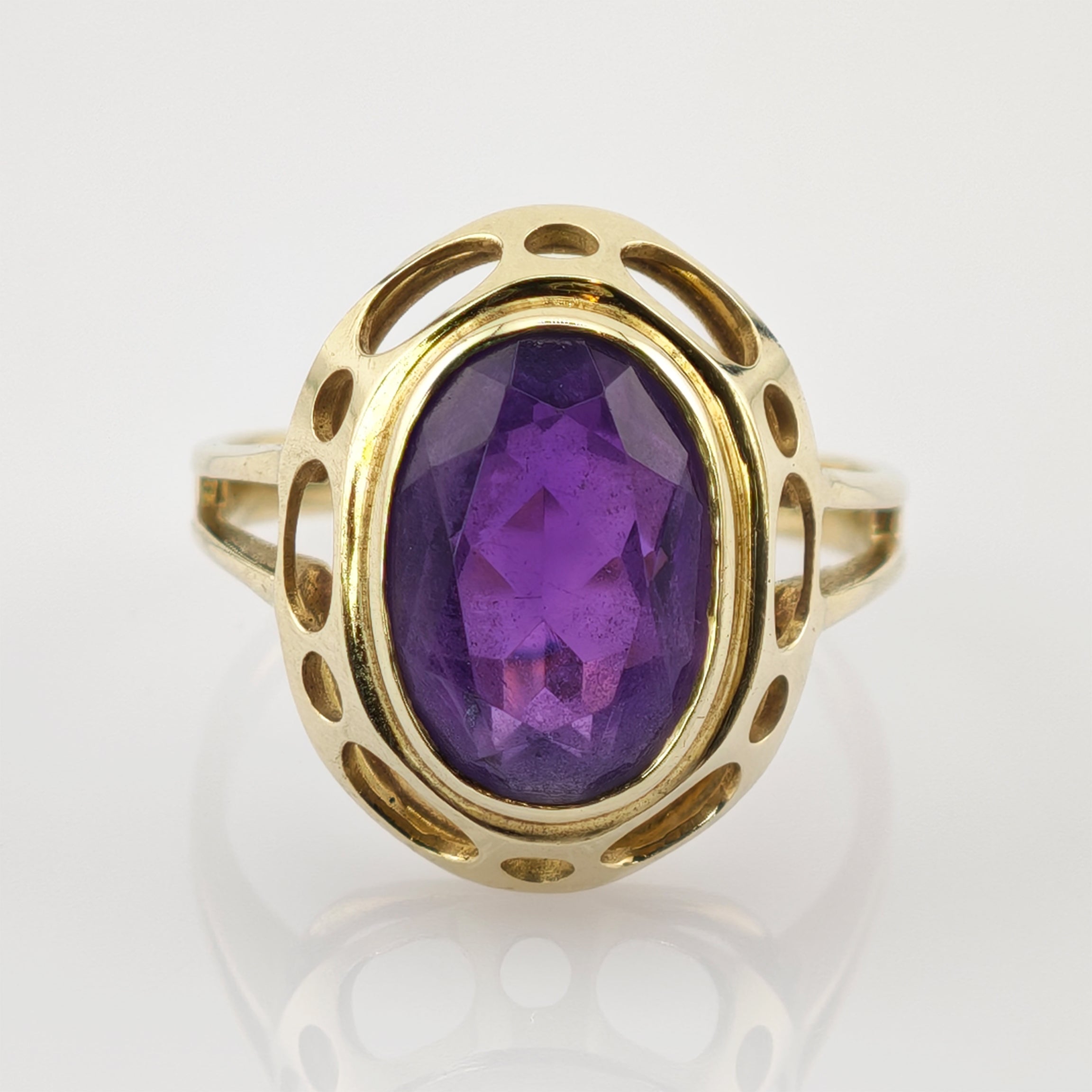 Goldener Ring mit ovalem Amethyst und offenem Design mit ovalen und runden Ausschnitten.