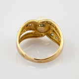 Nahaufnahme eines goldenen Rings mit Perle und detaillierter Innenstruktur, die feine Handwerkskunst zeigt