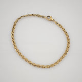 Goldenes Armband mit fein gearbeiteten Gliedern und Karabinerverschluss auf weißem Hintergrund.