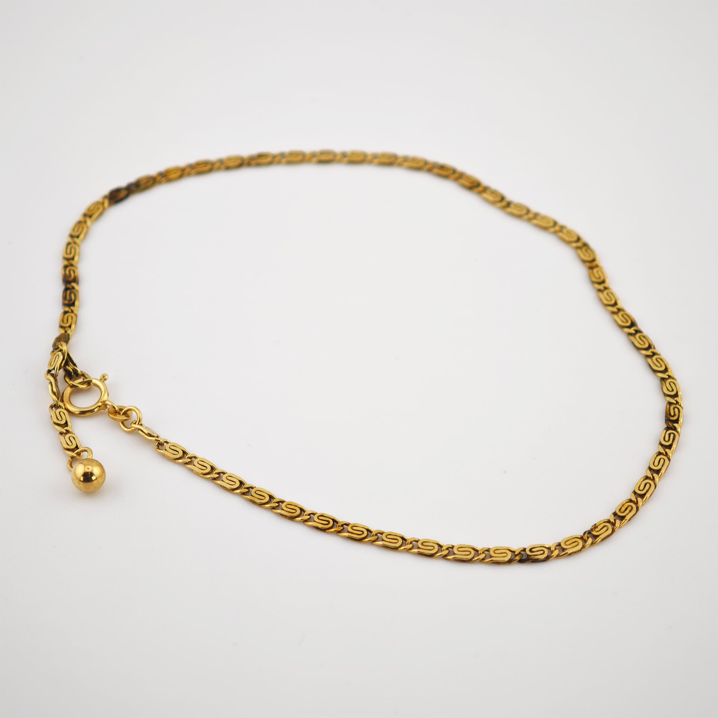 Goldenes Armband mit S-förmigen Gliedern und Federringverschluss mit Kugelanhänger