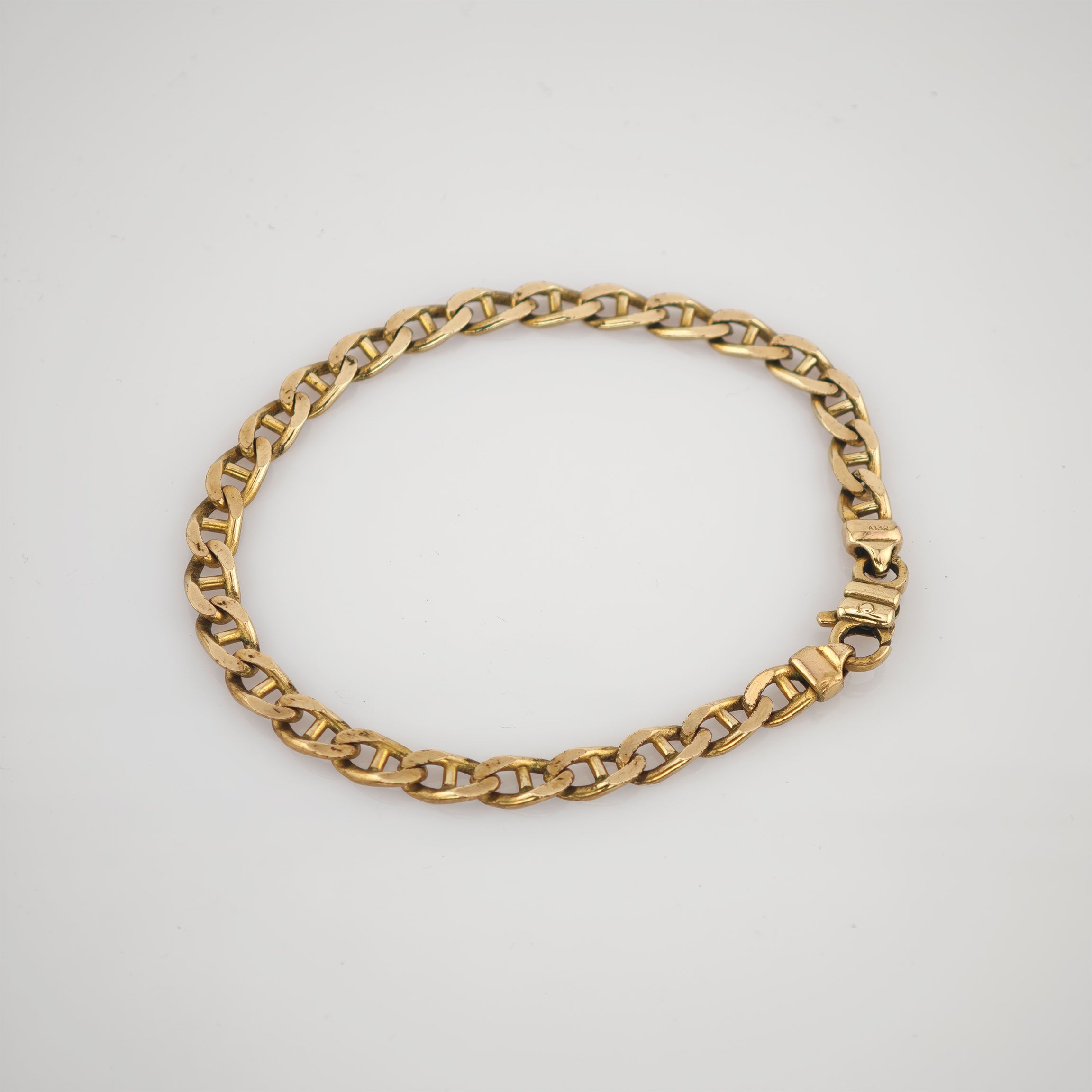 Goldenes Kettenarmband mit ovalen Gliedern in Kreisform auf weißem Hintergrund.