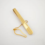 Goldfarbene Krawattenklammer mit matter Oberfläche und poliertem Rechteckdetail, goldene Kette und Hakenverschluss.