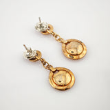 Goldfarbene Vintage-Hängeohrringe mit floralem Muster, silbernen Pfosten und Verschlüssen.