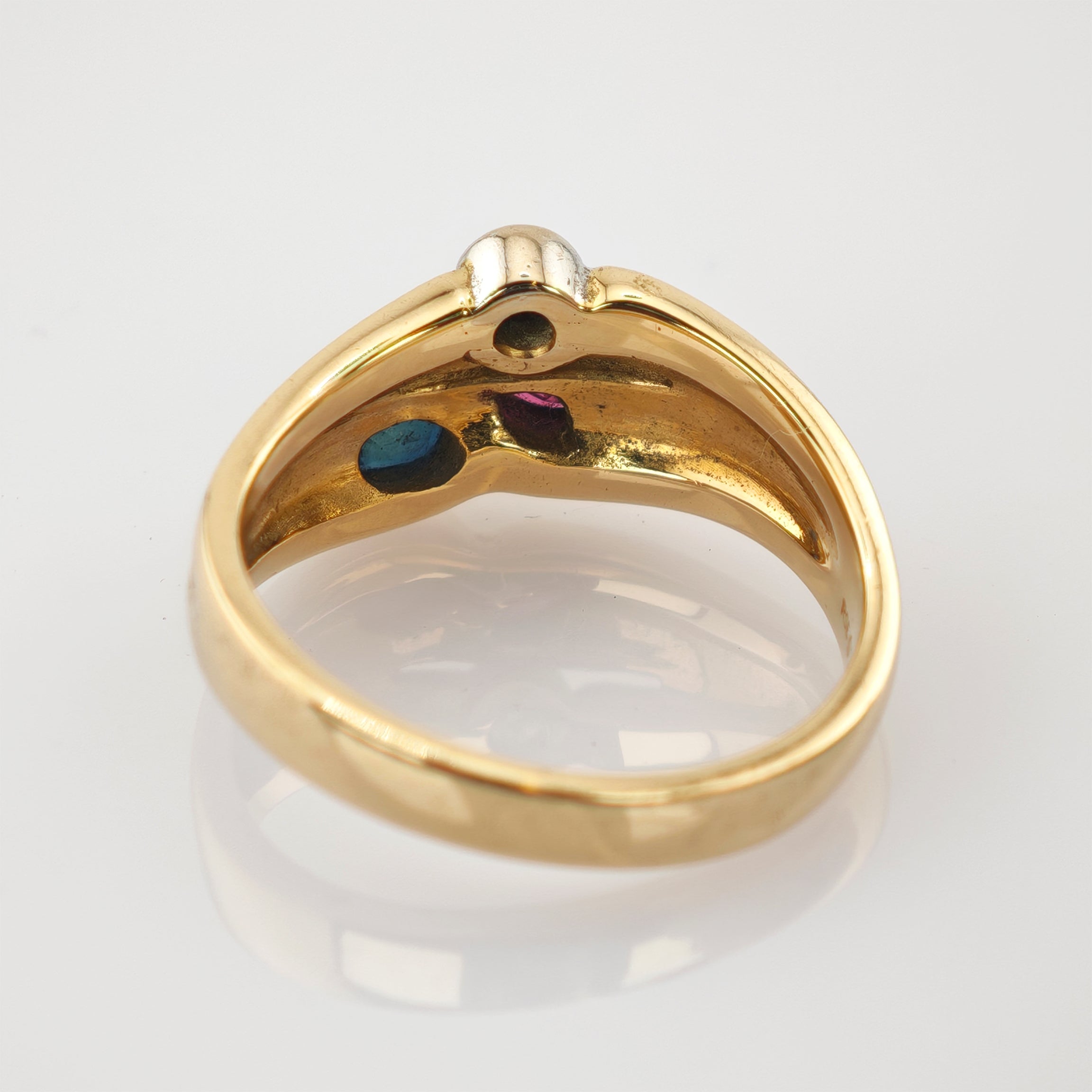 Goldring mit glattem Äußeren und blauen und violetten Reflexen im Innenband vor weißem Hintergrund