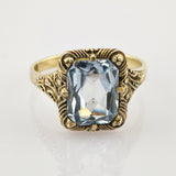 Goldring mit geschnitztem Band und rechteckigem hellblauem Edelstein