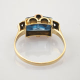 Goldring mit rechteckigem blauem Edelstein und detaillierter Fassung im Vintage-Design.