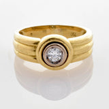 Goldring mit rundem Diamanten in erhöhter Fassung und dreifachem Rillen-Design, innen 750 gestempelt.