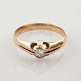 Goldring mit rundem klaren Stein in offener Fassung vor weißem Hintergrund