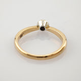 Goldring mit Weißgoldfassung und dunklem mittigem Loch, minimalistisches und elegantes Design.