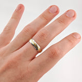 Hand mit silber-goldenem Ehering am Ringfinger vor weißem Hintergrund