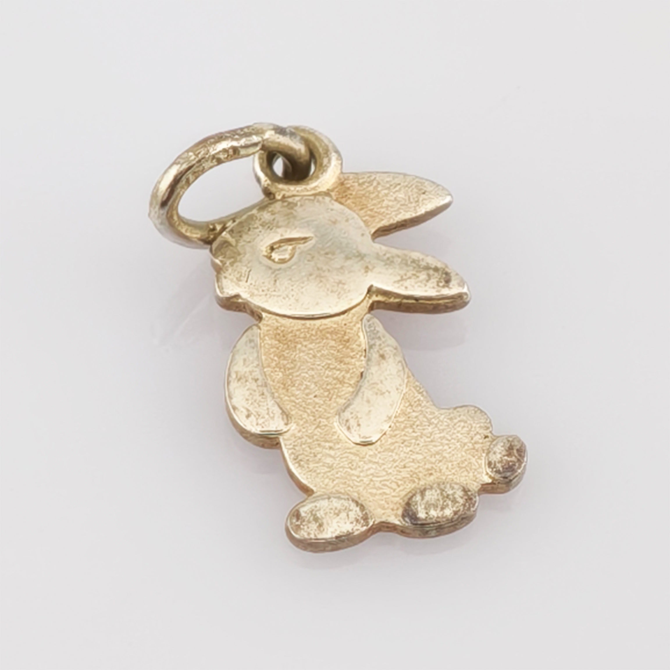 Kleiner goldener Anhänger in Form eines Kaninchens mit Ohren, Augen, Beinen und Schwanz