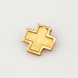 Kleiner goldener Anhänger in Kreuzform mit glänzendem Rahmen und mattiertem Mittelteil auf hellem Untergrund.