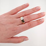 Linke Hand mit blassrosa lackierten Nägeln trägt zweifarbigen Ring aus Gold und Silber mit Diamant.