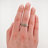 Linke Hand mit natürlichem nudefarbenem Nagellack und silbernem Ring mit klarem Edelstein am Ringfinger.