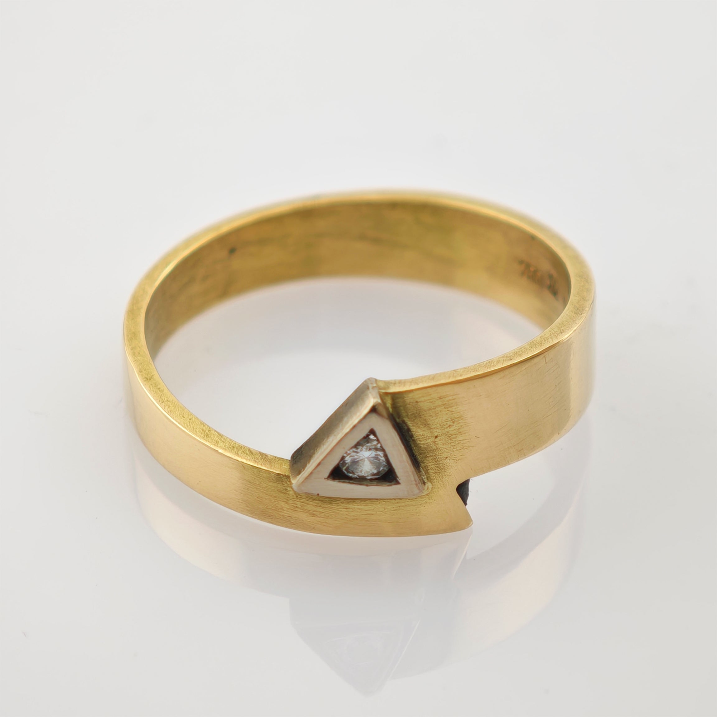 Massiver Goldring mit flachem Band, dreieckiger Fassung aus Silber und rundem Diamanten.